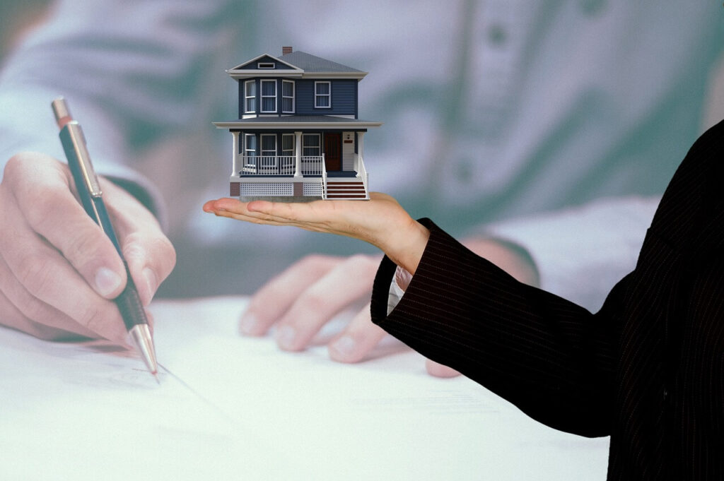 George Properties Real Estate Free Valuation image of house with someone writing and an miniature house
