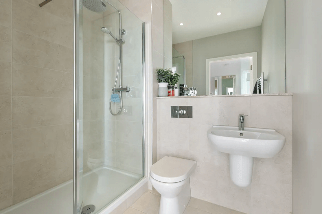 59 Campion Marina Village Greystones bathroom with full shower and glass doors and white sink and toilet with large mirror and light fittings