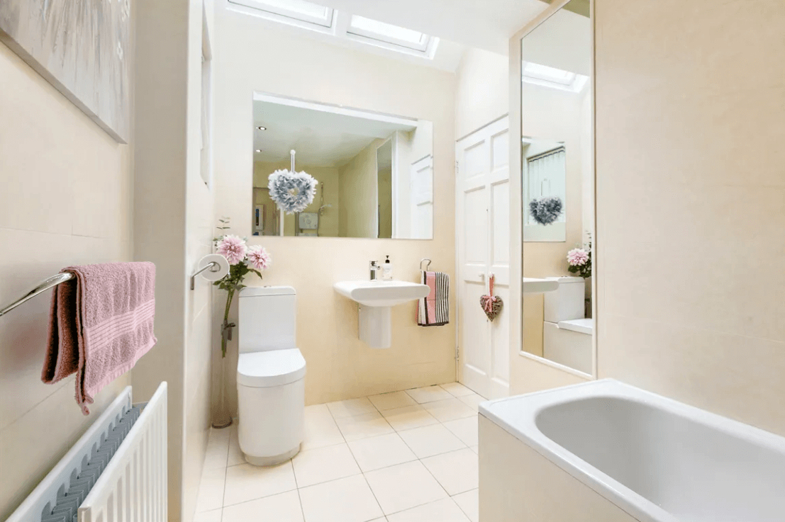 129 Wesbury Stillorgan Dublin main bathroom with full white bath and sink with large mirror and white tiled floor