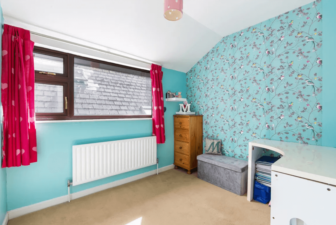 129 Wesbury Stillorgan Dublin bedroom 2 with blue walls, timber flooring, large white radiator and large window with view of adjacent property