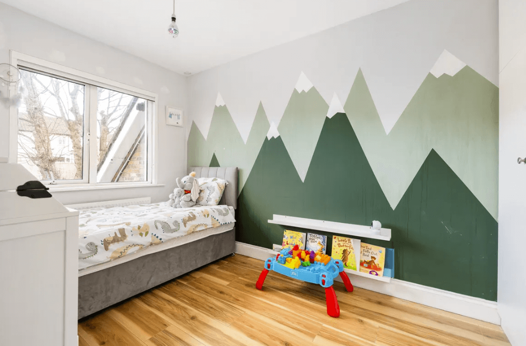 17 The Courtyard Brookwood Bray bedroom 2 with child's bed, timber flooring, medium-sized window and mountains painted on walls