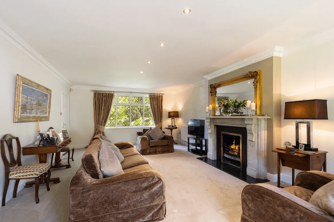 Balfour Ferndale Road Rathmichael Dublin George and Maguire Properties living room with lighted fire, large, luxurious sofas and window view outside