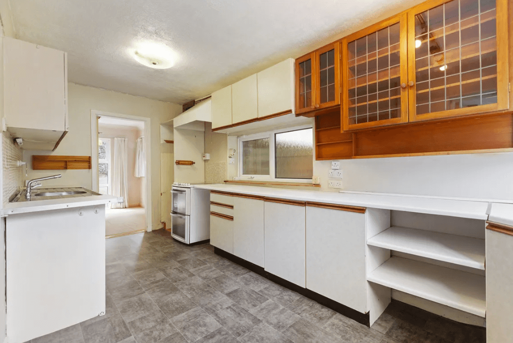 87 Shanganagh Vale Cabinteely Dublin George and Maguire Properties kitchen with white cupboards, grey linoleum floor and doorway to dining room