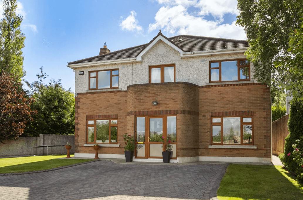 1 Leopardstown Rise Leopardstown Dublin 18 by George and Maguire Properties front view the house with large garden and trees lining he boundary walls